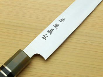 Sujihiki knife blade with engraved characters and dark horn handle, angled top view.