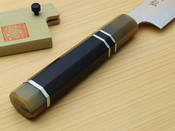 Sujihiki knife handle with triple ring accents and dark finish, laid on wood.