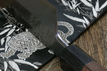 Japanese kama usuba knife blade edge and dark handle, close-up of cutting edge.