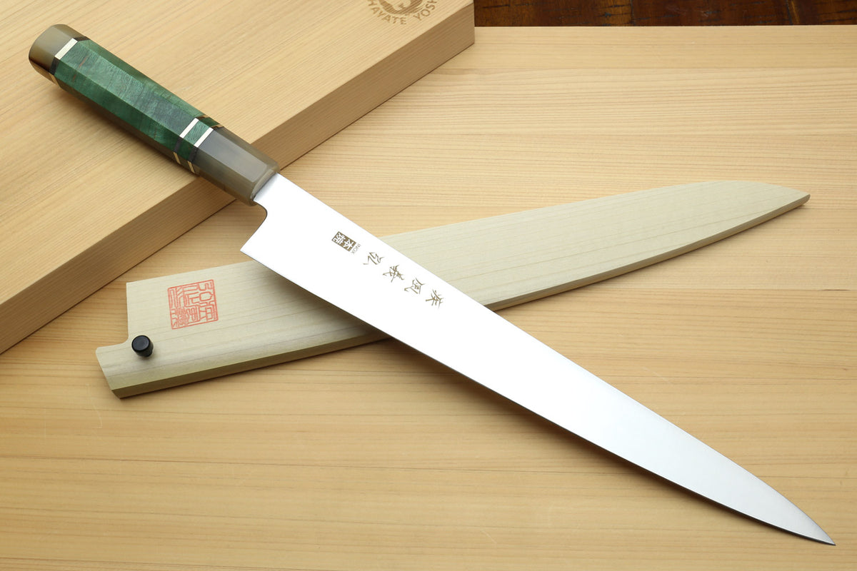 Sujihiki slicer knife with white blade, dark green handle, and wooden saya sheath