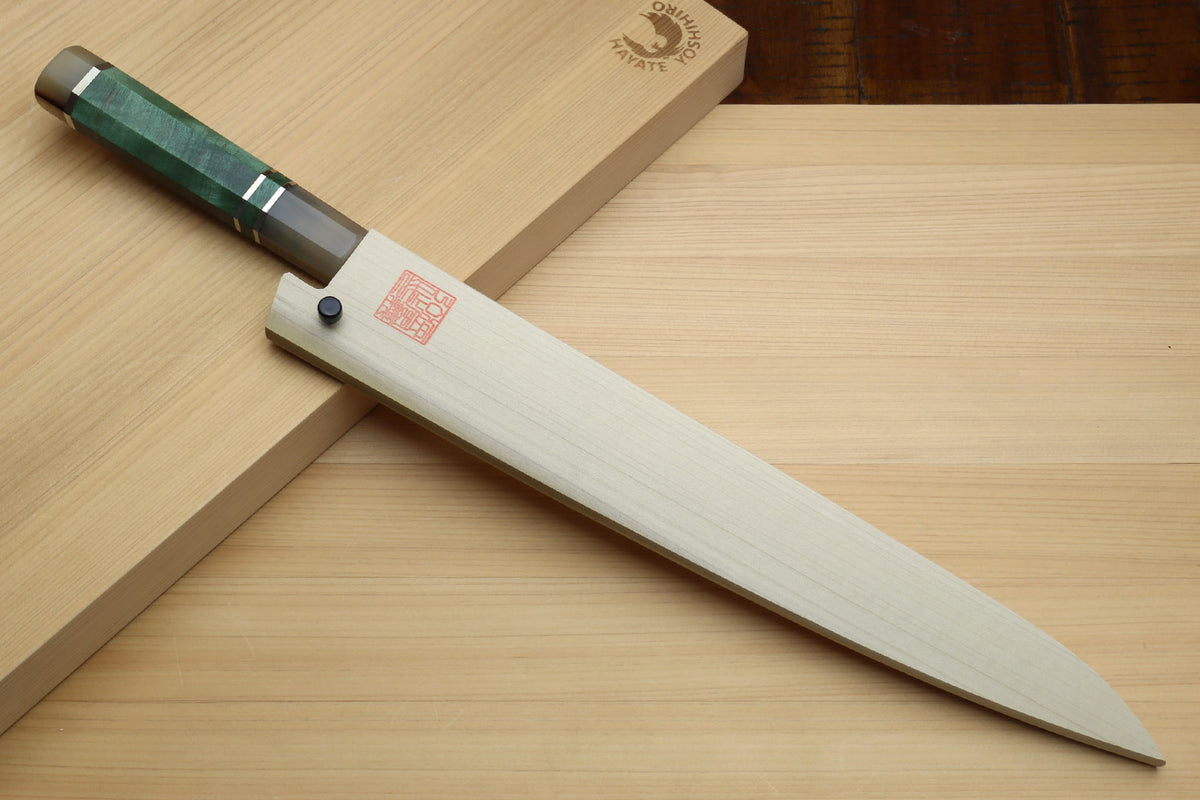 Sujihiki slicer knife with wooden saya and dark green handle on wooden surface
