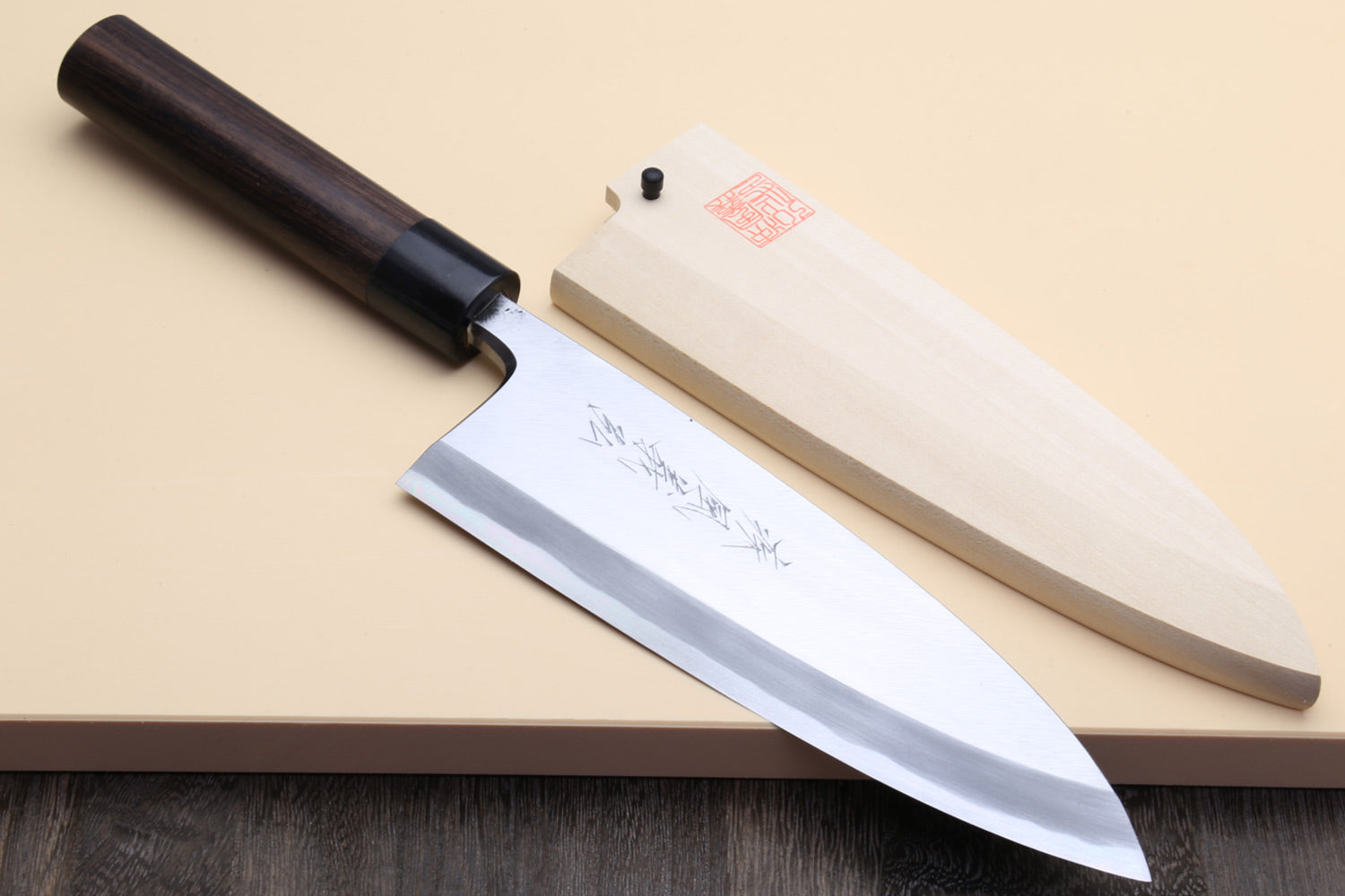 Chef's knife with wooden handle on a beige surface