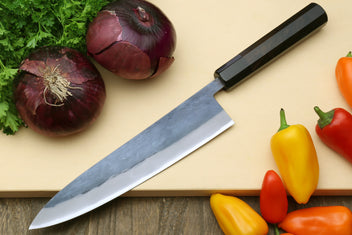 Gyuto chef's knife with black handle and blue steel clad stainless blade, side view