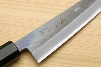 Utility knife blade close-up with blue-grey hammered finish and dark handle