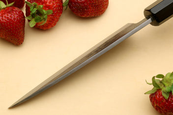 Petty utility knife with dark ebony handle and stainless blade, side angle