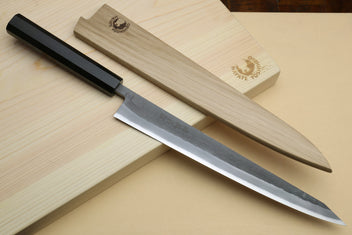 Slicer knife with ebony handle and silver blade with light wooden saya-style cover pieces.