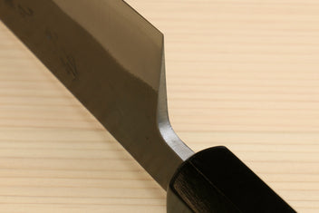 Kiritsuke slicer knife showing blade heel curve and dark ebony handle.