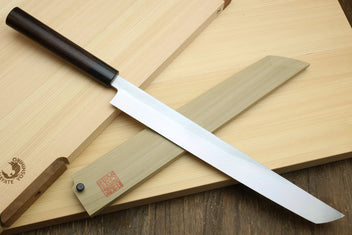 Japanese sushi sashimi knife with white steel sakimaru blade and dark wood handle on board