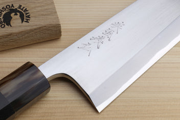 Deba knife close-up of white blade with etched markings and dark handle