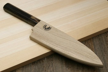 Deba chef knife on wooden board with white blade and ebony-style dark handle