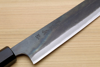 Japanese utility kiritsuke knife close-up of blade spine markings and dark wooden handle