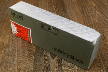 Natural sharpening whetstone block with printed label panel and light stone face