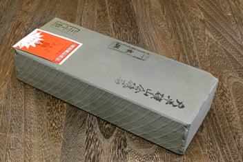 Natural sharpening whetstone, long rectangular light gray with orange label on side