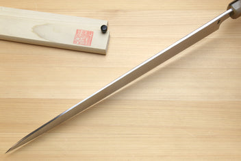 Yanagi sushi knife with mirror blade, horn handle, and wooden sheath on table