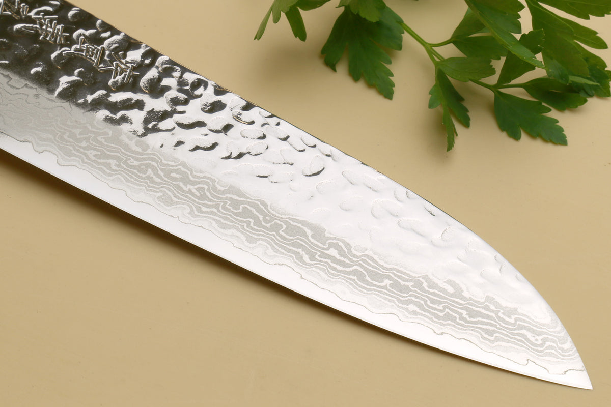 Damascus blade with hammered pattern and engraved characters along the edge