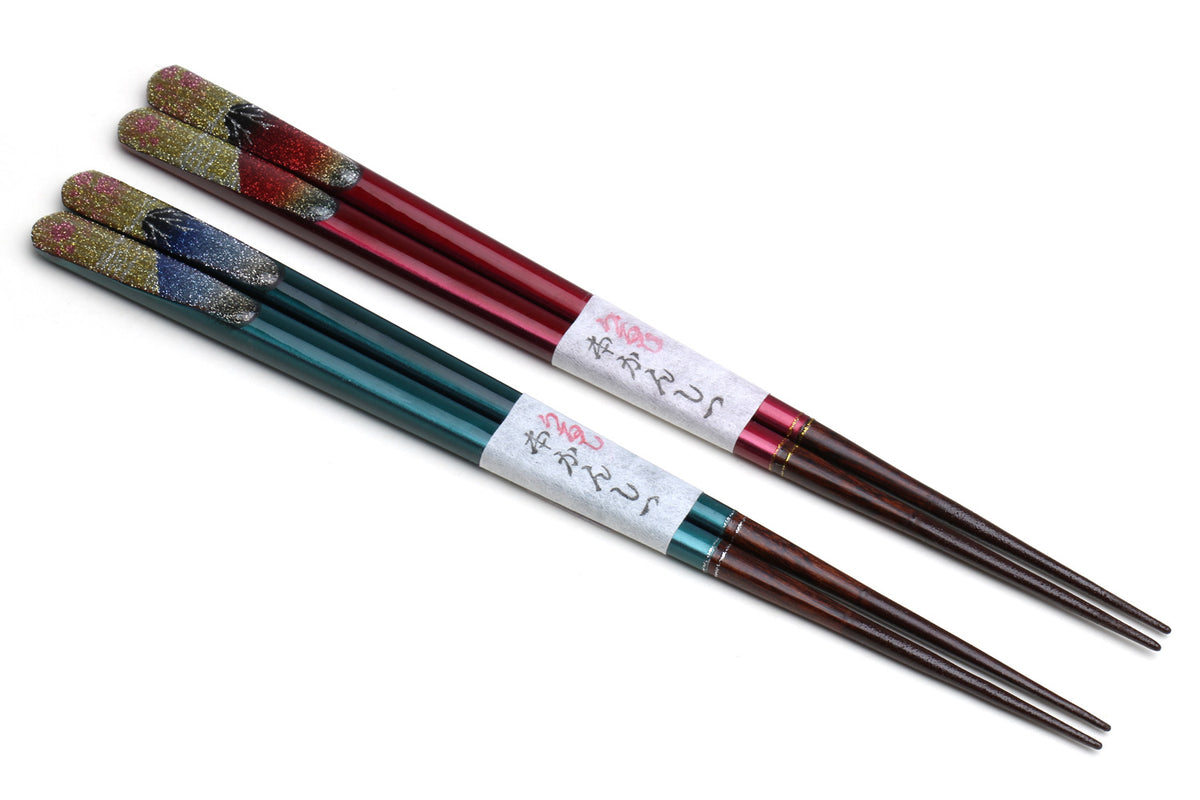 Four glitter lacquer chopsticks with red, teal, and multicolor bands