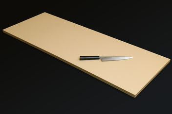 Cream Japanese cutting board with chef knife and black bolster on the board.