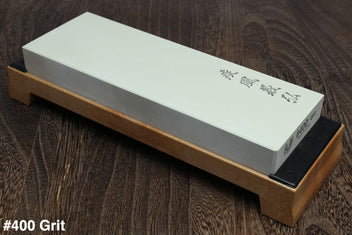 400-grit sharpening whetstone on wooden base, pale green stone with dark label edge