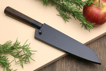 Petty utility knife beside a dark blade sheath; shitan wood handle visible.