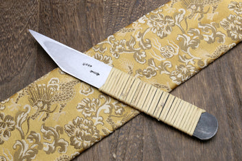 Kiridashi utility knife showing blade markings and ribbed light wooden handle