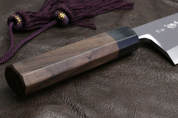 Deba knife with shitan handle and purple cord over the light wooden saya