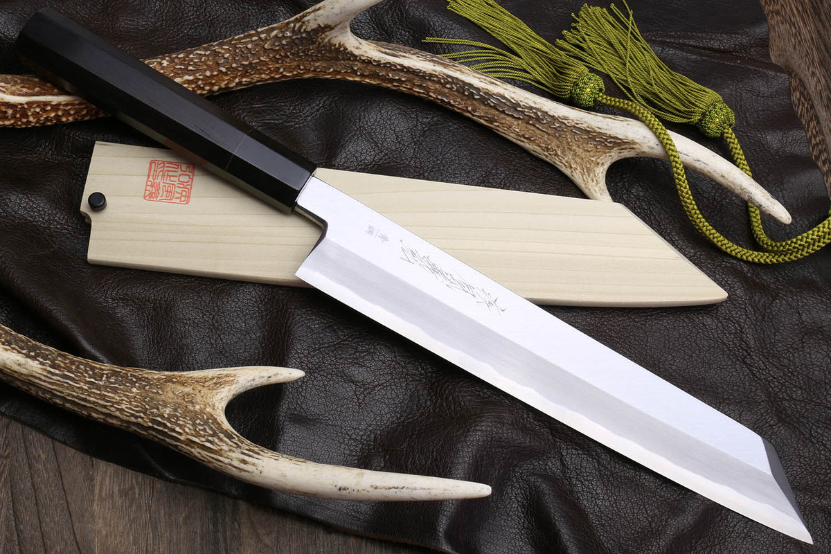 Multipurpose chef knife with silver blade, black handle, light wood sheath