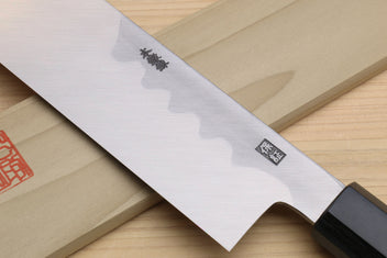 Japanese vegetable knife close-up of pale blade with curved cutout and dark handle