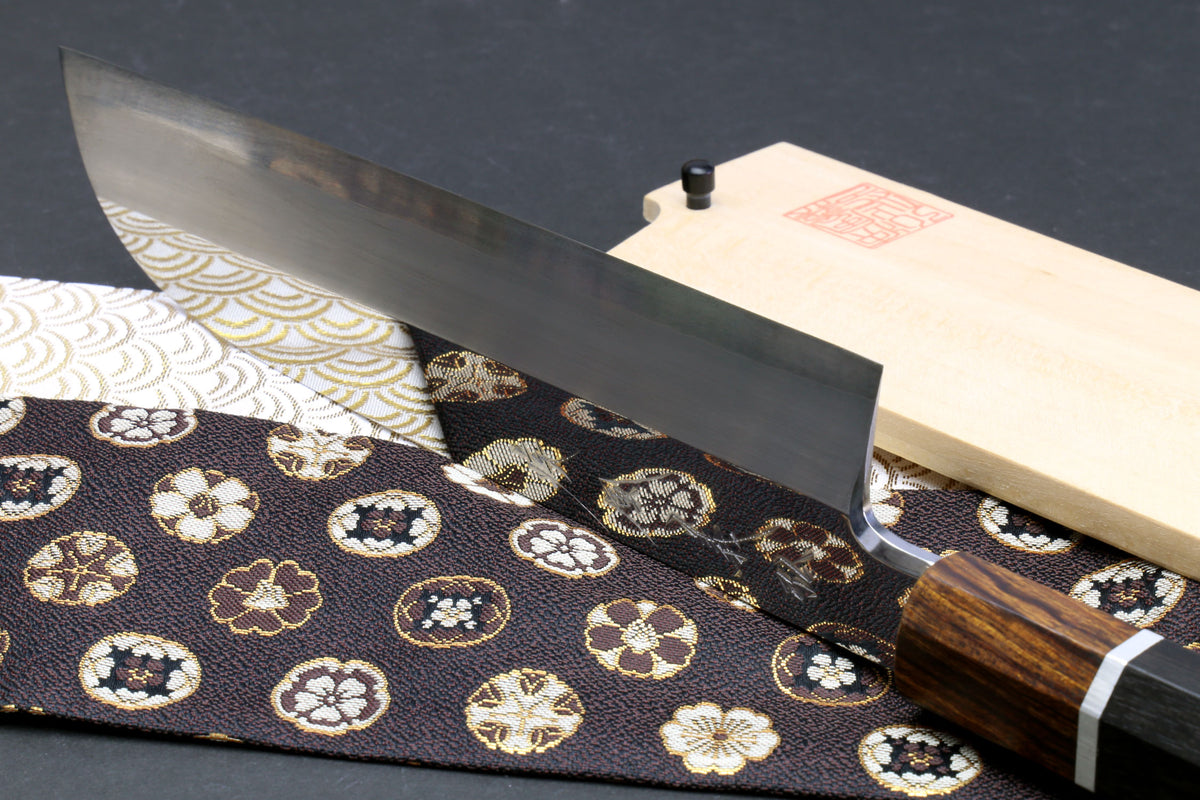 Japanese chef knife showing flat grind blade and ebony handle with silver ring