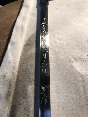 Single-edged tuna knife blade closeup with etched Japanese characters