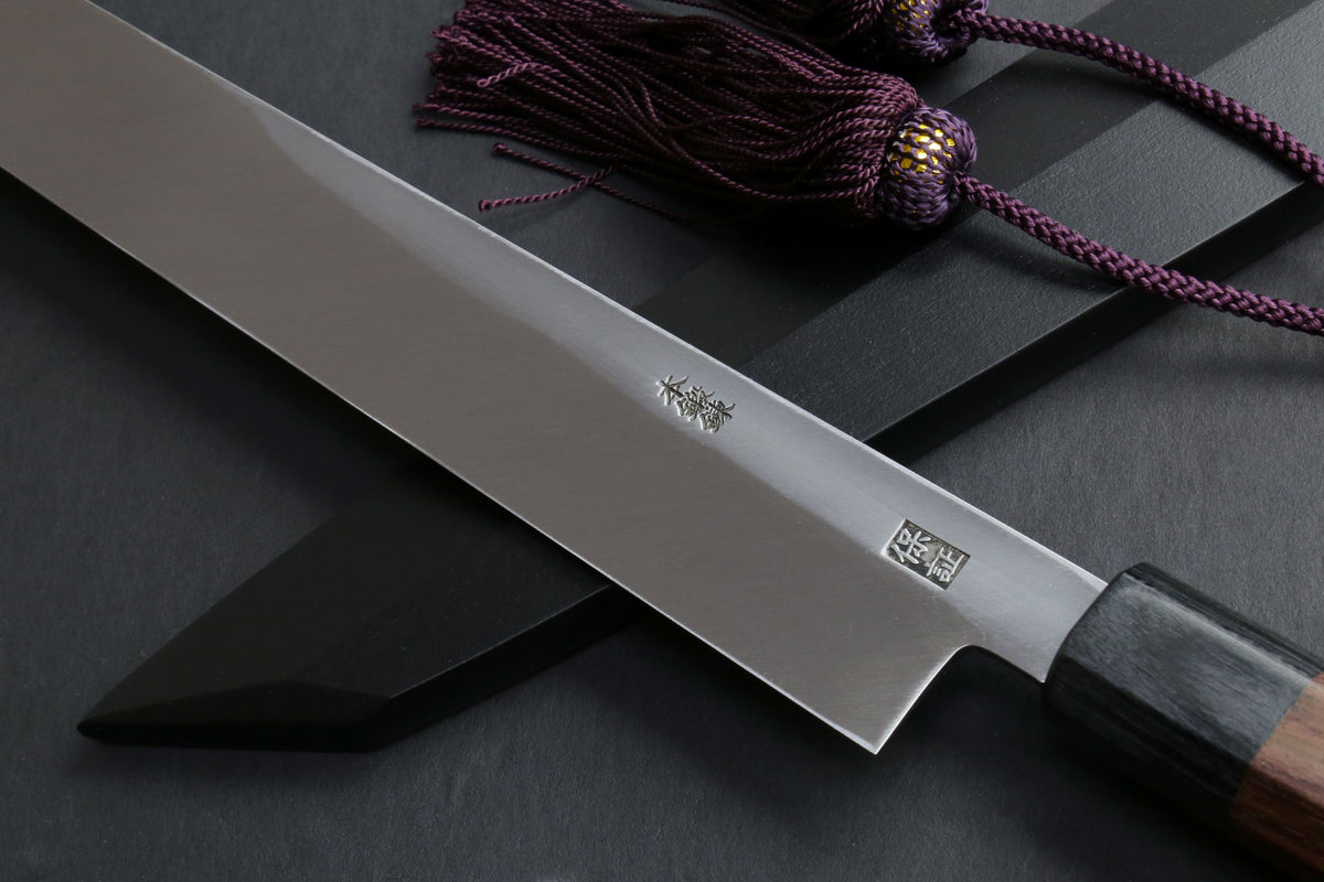 Japanese yanagi knife close-up: steel blade with logo and rosewood handle