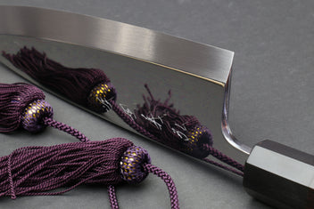 Mirror-finished deba sushi fillet knife with dark handle and purple braided cords