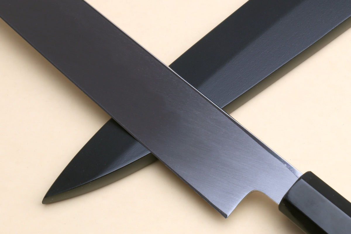 Yanagi knife at an angle with long mirror-finished blade and dark handle.