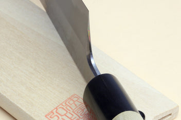 Japanese vegetable chef knife close-up: dark blade against light wood handle and black collar.