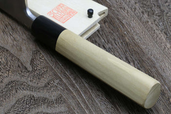 Japanese chef knife close-up with light wood handle and silver blade root