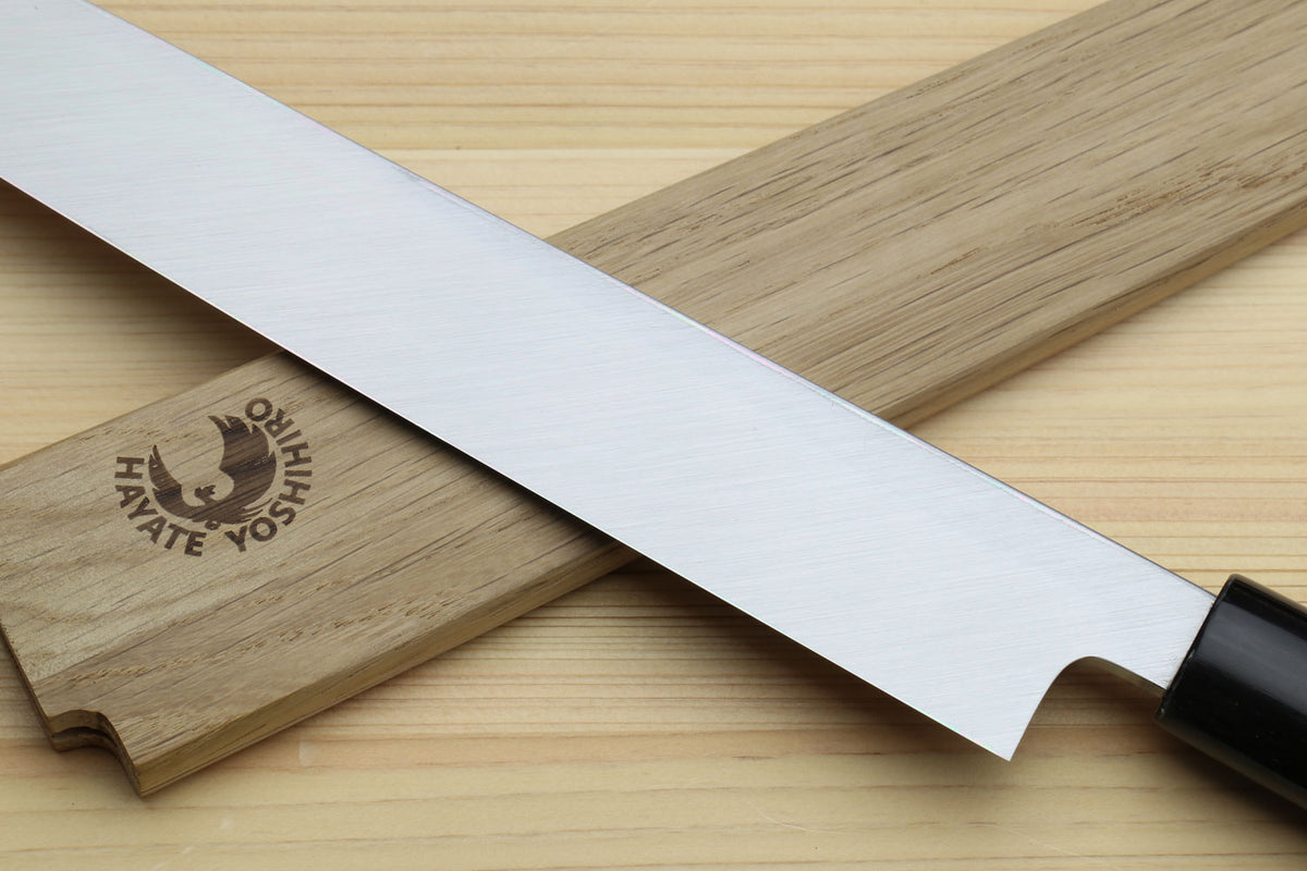 Yanagi sushi knife with white blade and rosewood handle in focus