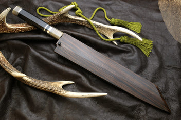 Kiritsuke knife with dark handle, horn sheath, and green cord tassel.