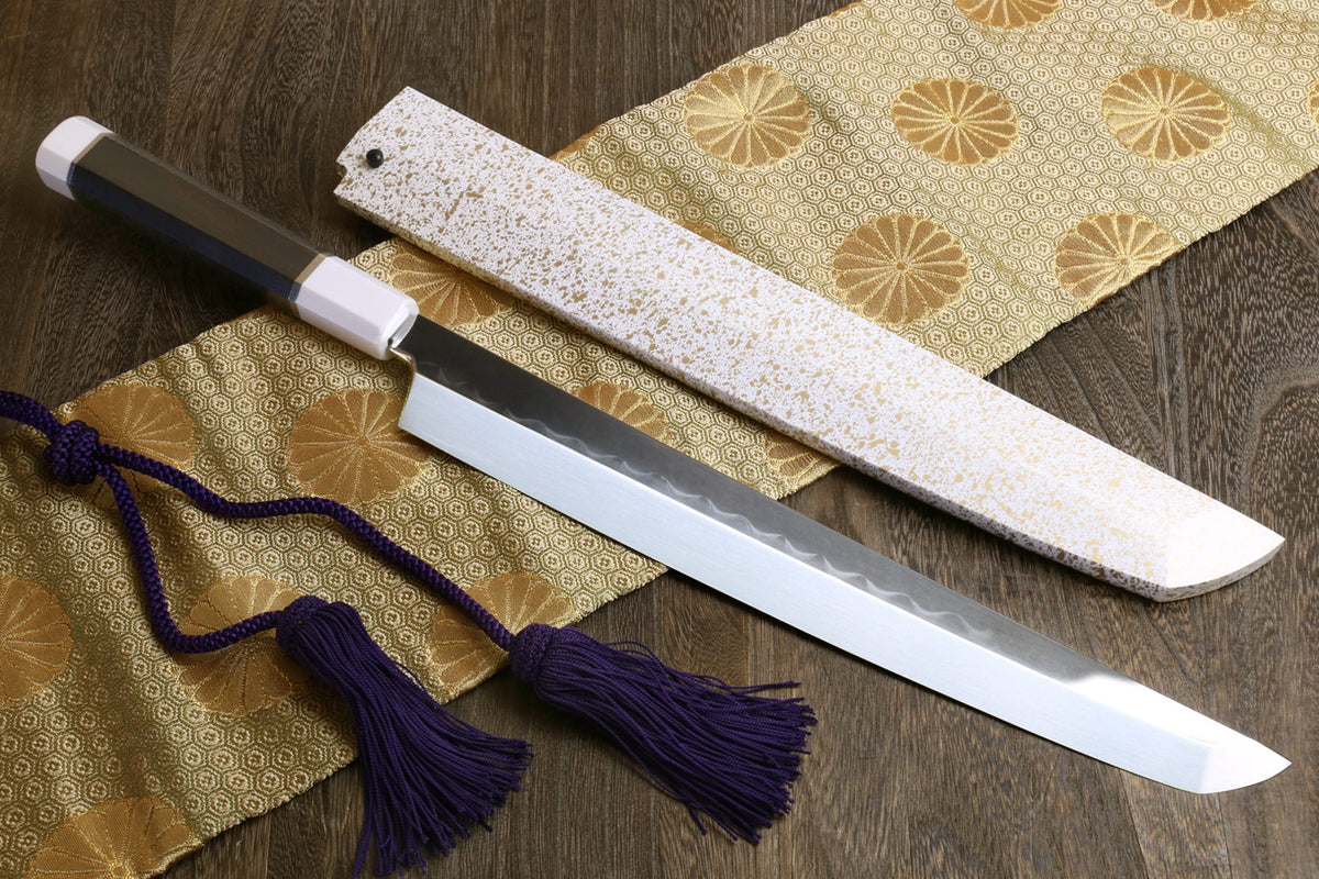 Japanese sushi sashimi knife with exposed silver blade, white saya, dark handle, purple tassel
