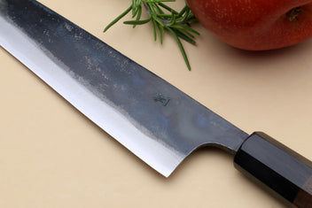 Petty kiritsuke knife detail of kurouchi blade markings near bolster and edge