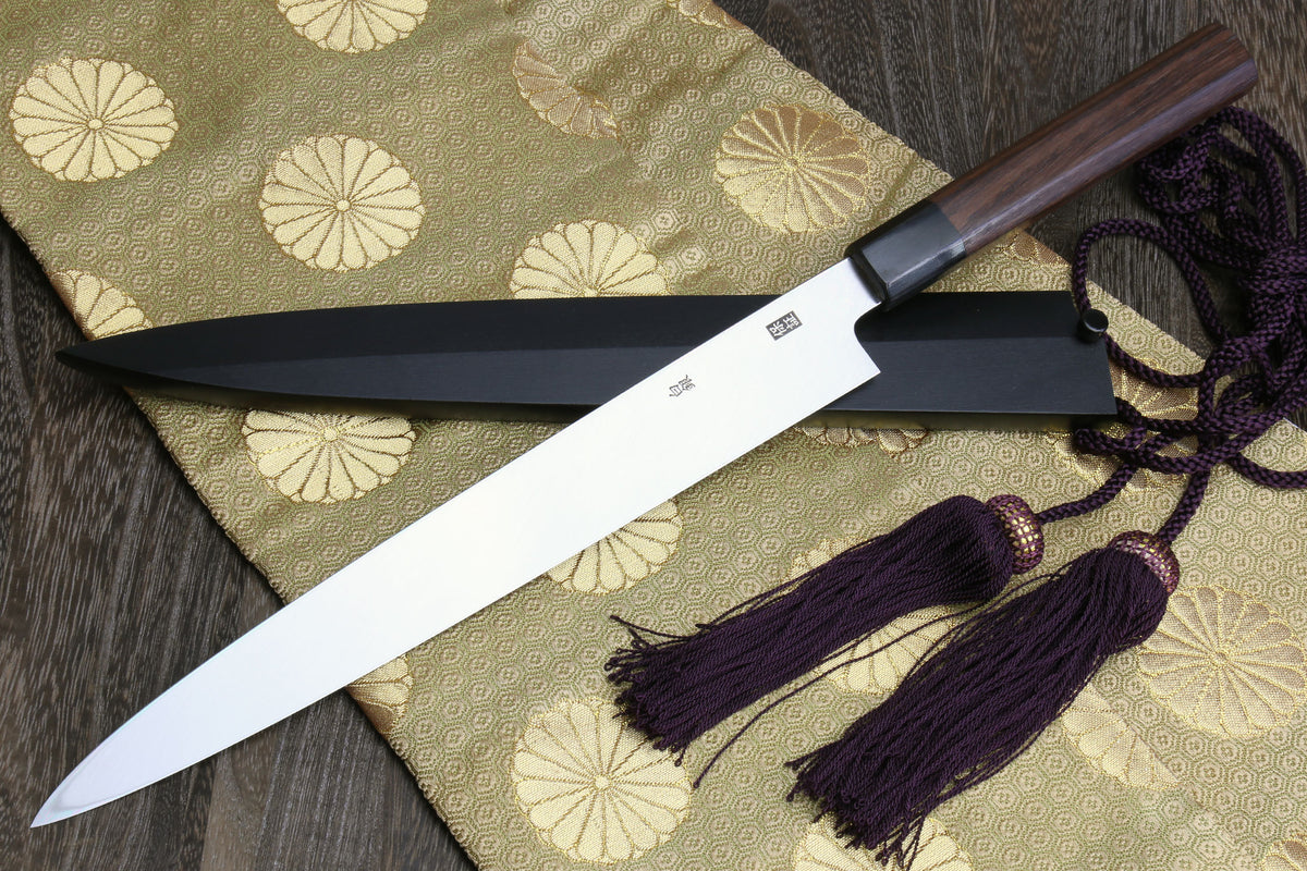 Japanese yanagi sushi knife with rosewood handle, dark saya, and purple cord tassels