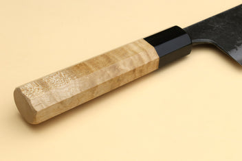 Nakiri knife handle detail, camphor wood grip with black bolster and dark blade
