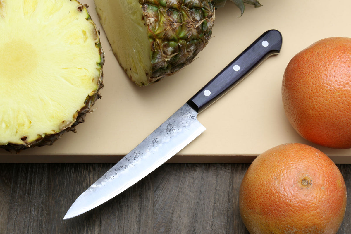 Petty utility knife with dark handle and pointed silver blade