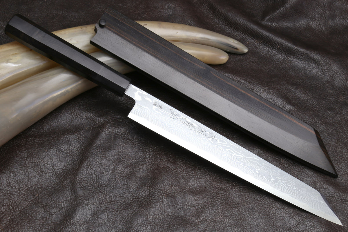 Japanese yanagi sushi knife on dark leather, damascus blade with ebony handle