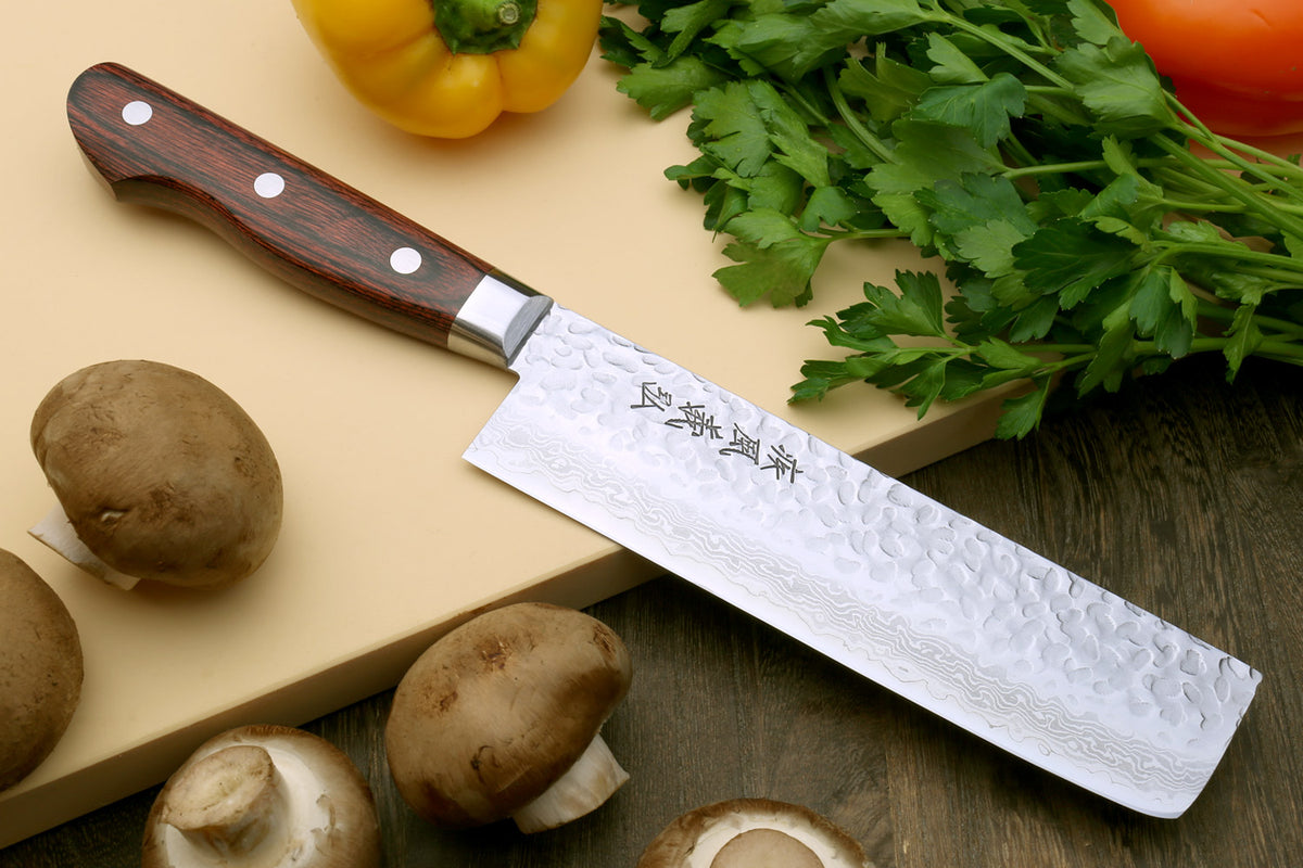 Damascus chef knife with dark wood handle and hammered blade texture