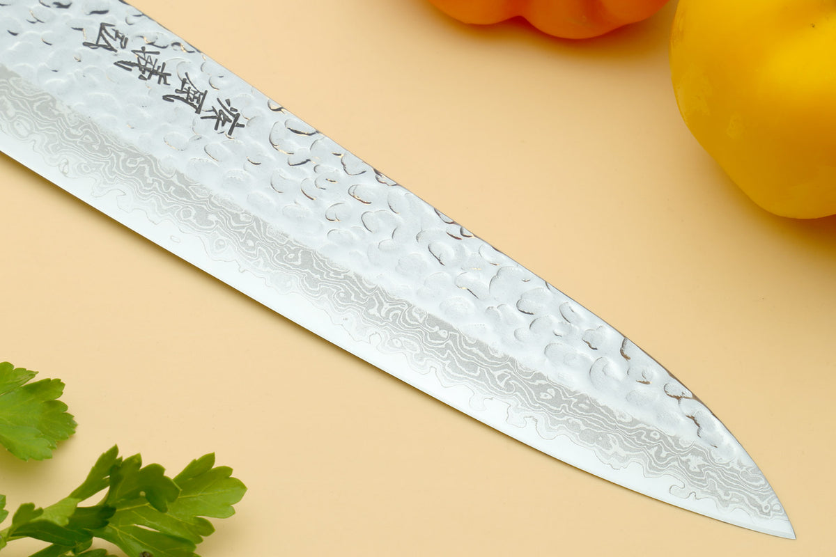 Hammered Damascus paring knife blade close-up with dark speckled texture